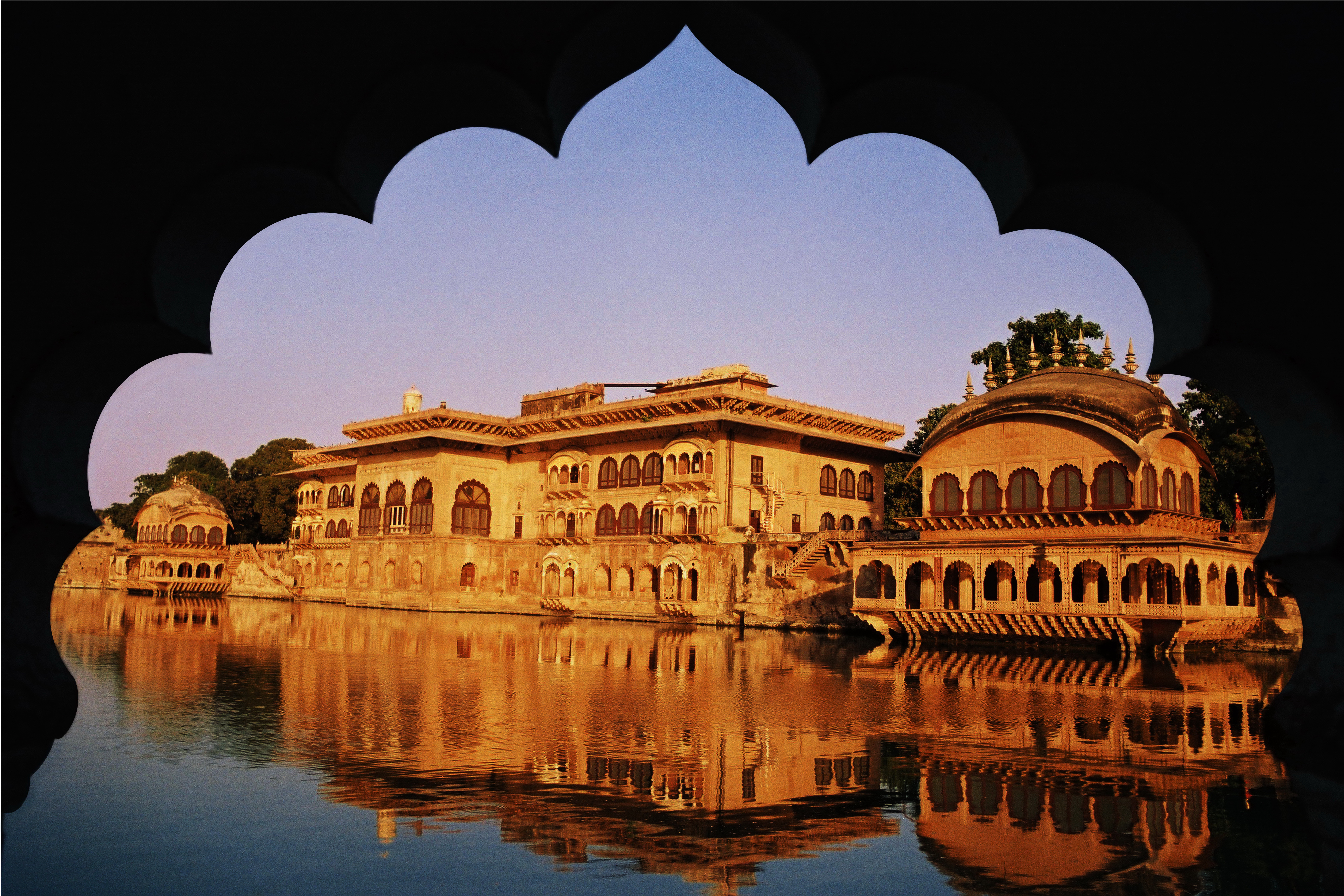 Historic Indian royal palace reflected in lake water with traditional heritage architecture and arched frame view
