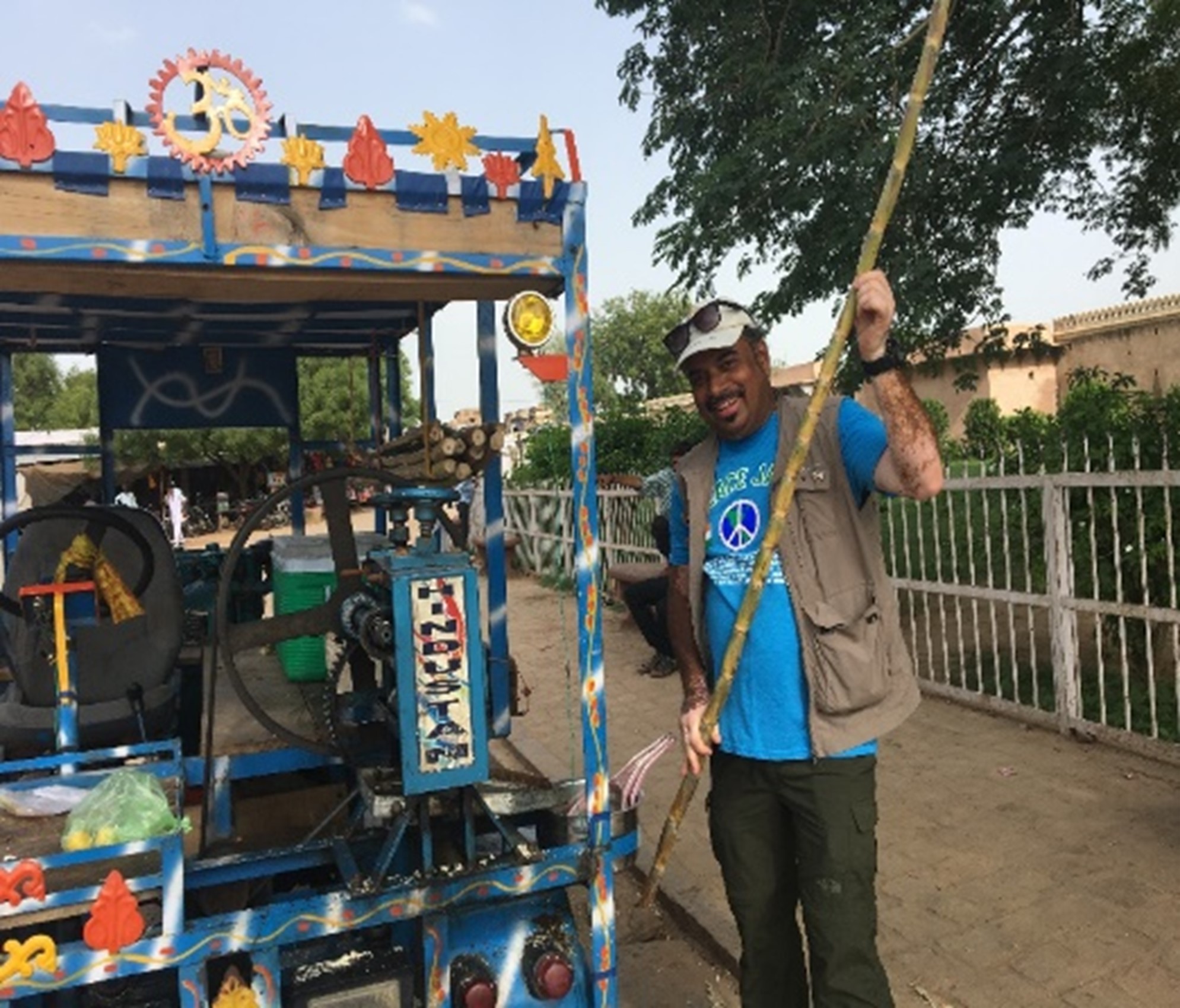 Ramesh Nambiar standing near a traditional sugarcane juice cart during a cultural tour in Rajasthan, India