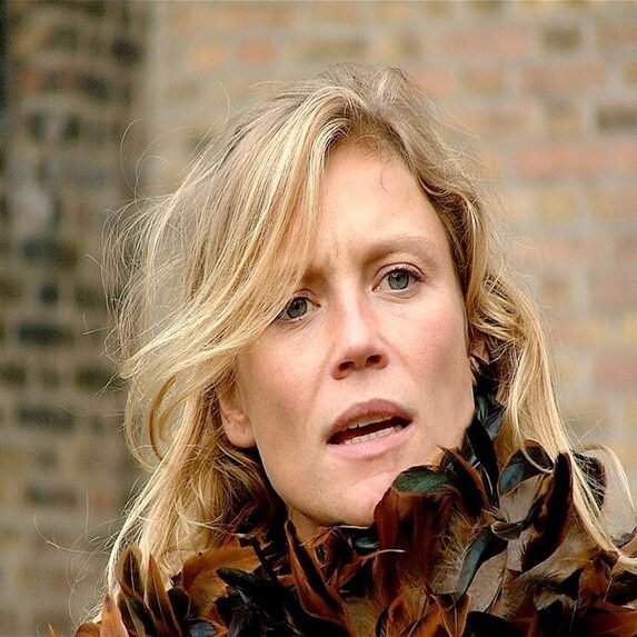 Close-up portrait of Dutch actress Sophie Hilbrand wearing a feathered garment, known for the series Try Before You Die.